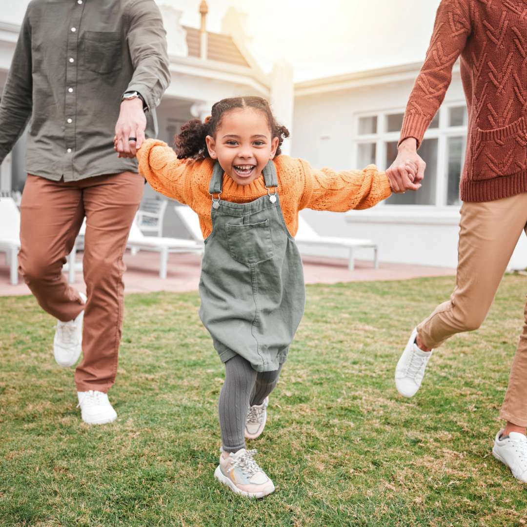 Happy family holding hands and walking with smiling child